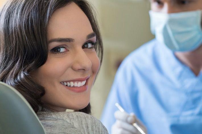 אישה צעירה מחייכת לאחר טיפול שיניים להרמת סינוס ושיקום הפה