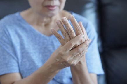 אישה מבוגרת סובלת מכאבים במפרקי האצבעות בשל דלקת פרקים, פרדניזון 